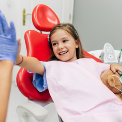 Smiling child giving dentist high five