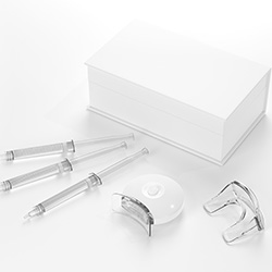 Clear teeth-whitening kit supplies on white background