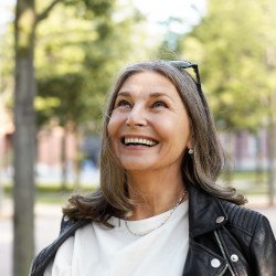 Senior woman walking down street and smiling