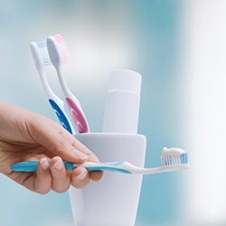 a person holding a toothbrush with toothpaste