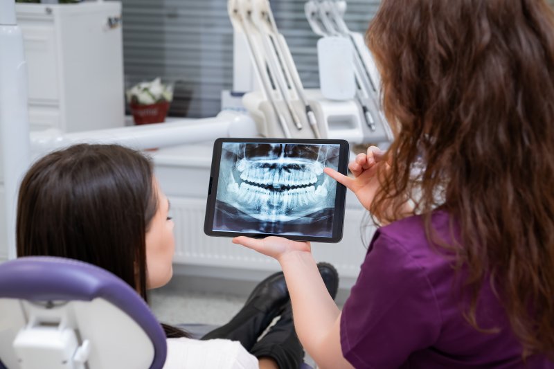 A dentist showing a patient a dental x-ray